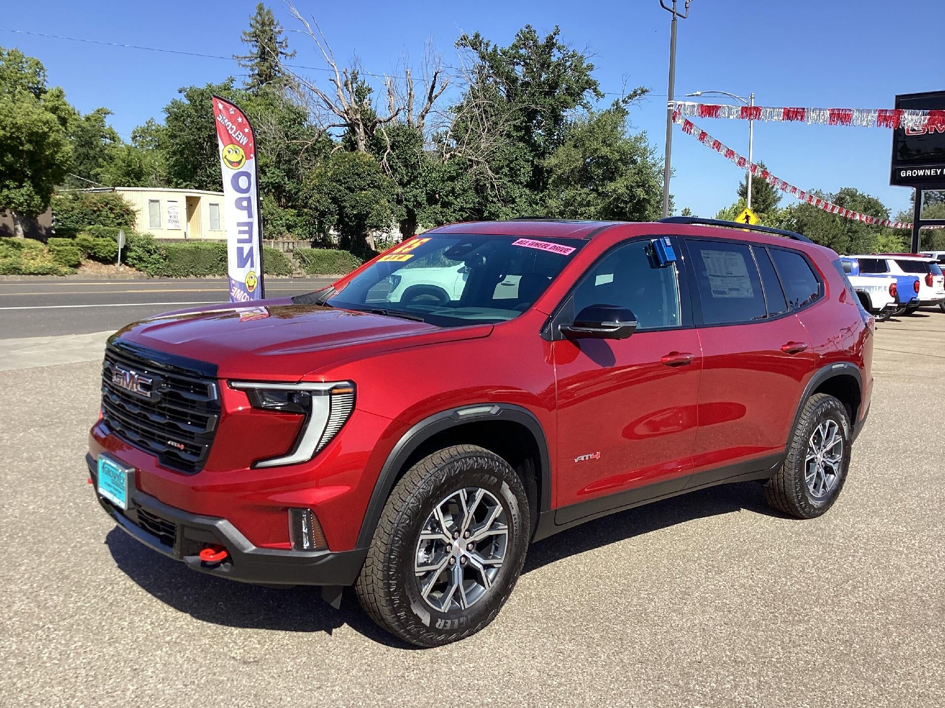 2025 GMC Acadia AT4 in Volcanic Red Tintcoat — front three-quarter view